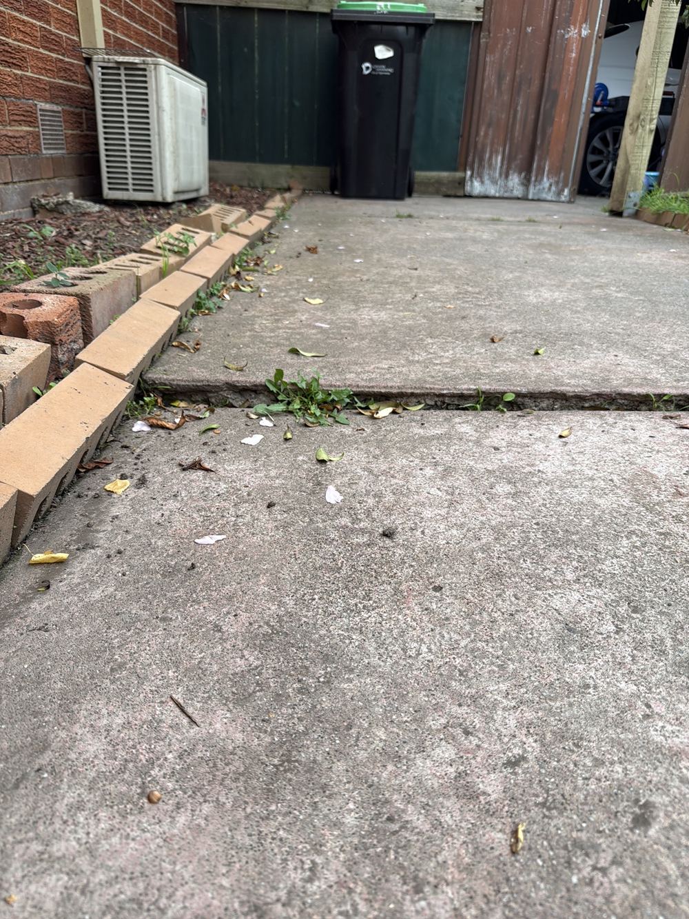 Concrete paths heaved up into trip hazards beside the house, found during a pre-purchase inspection in Dandenong North